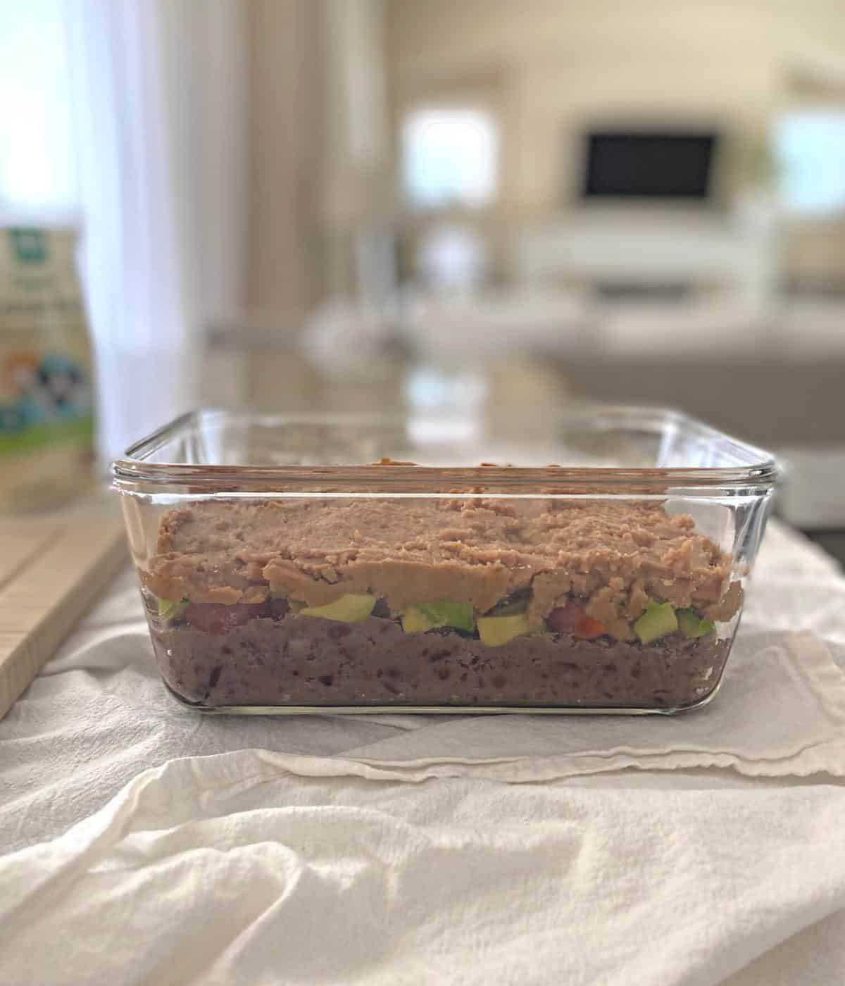 Seven layer dip from the side in a glass container