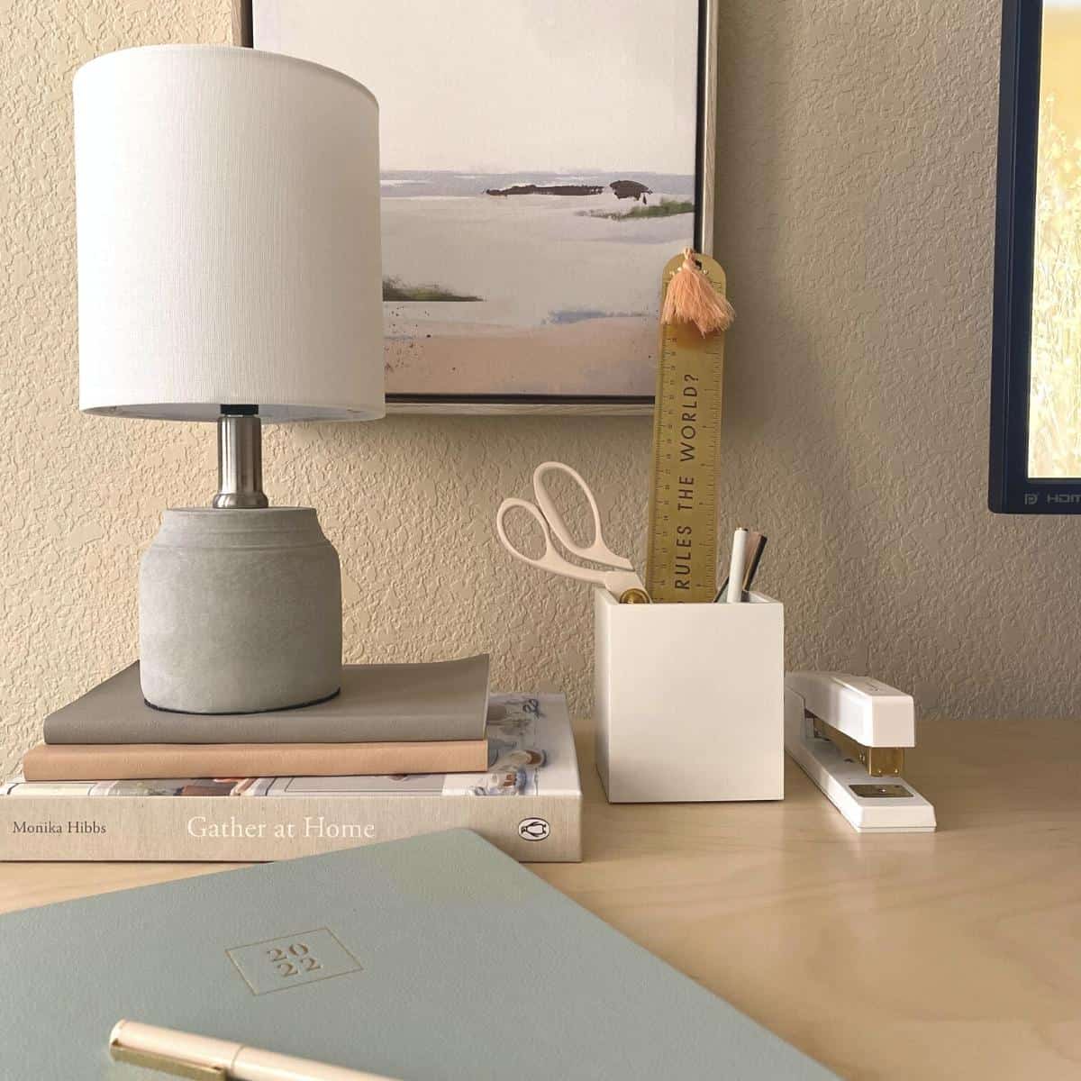 Aesthetic desk accessories with a small art print on the wall.