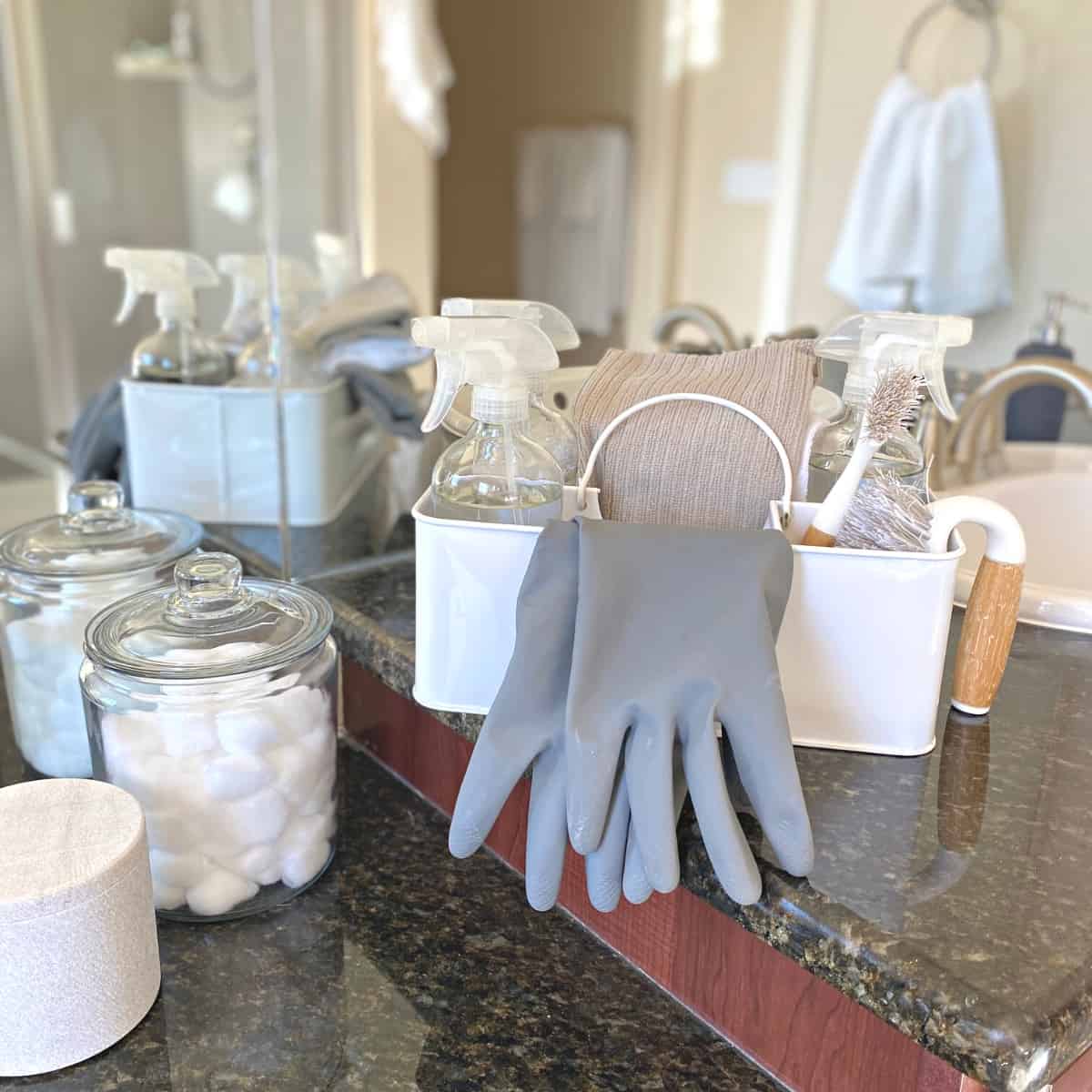 White bathroom caddy with cleaning products, gloves and towels
