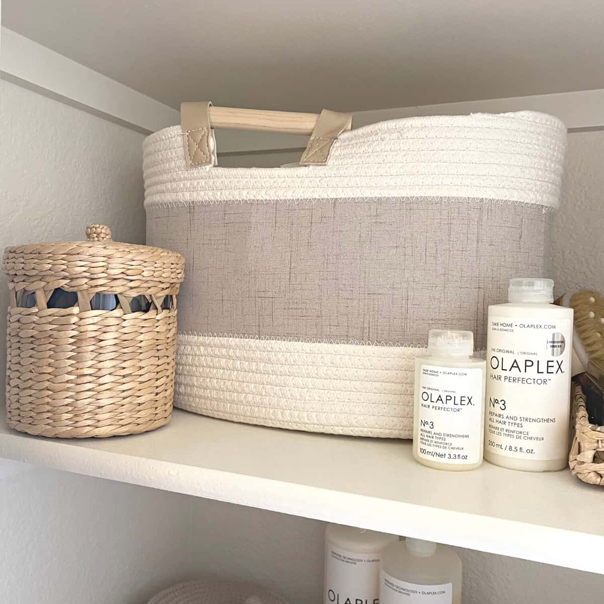 Small woven canister next to a basket and hair care products