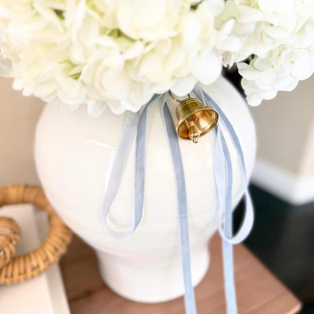 vase with ribbon and a bell tied to it