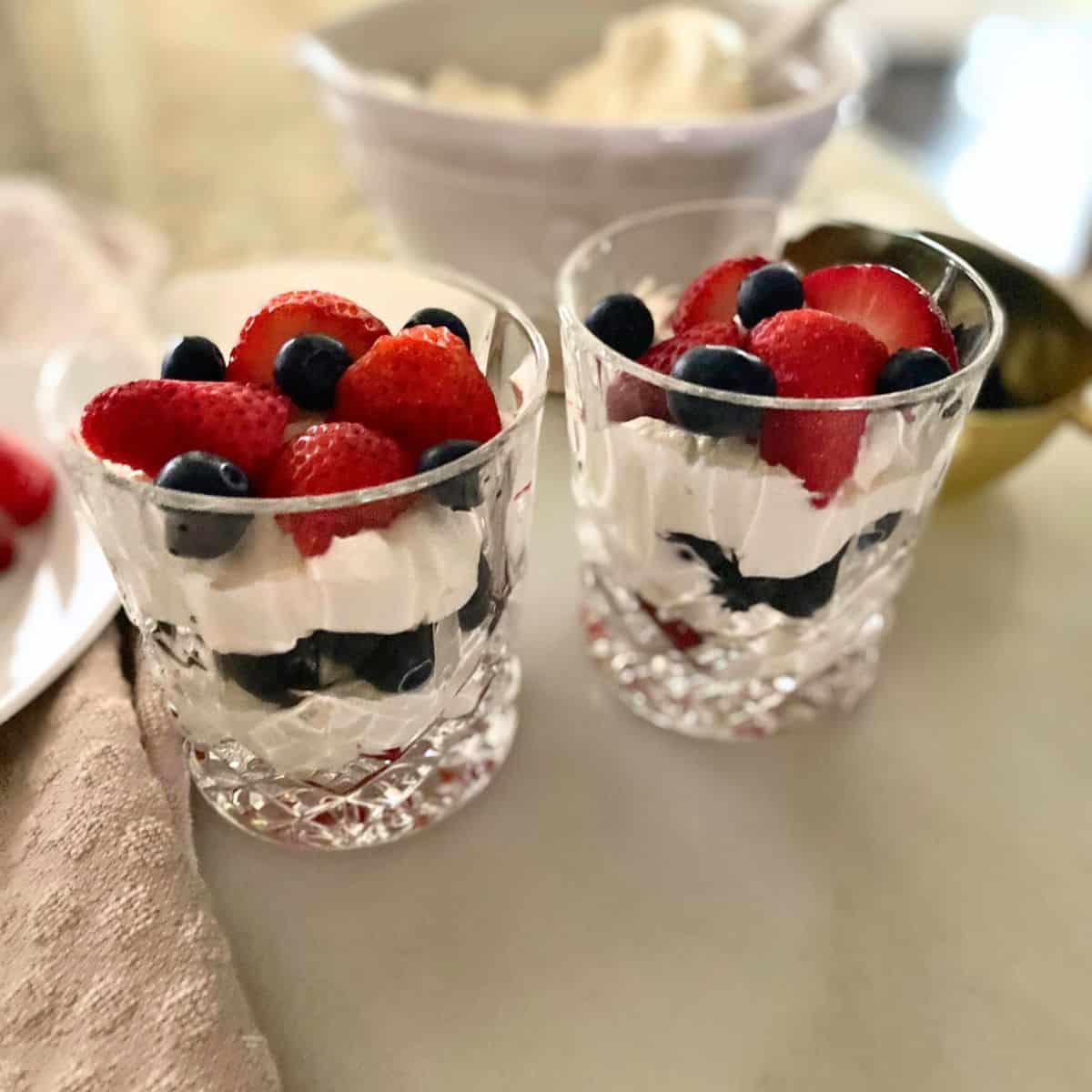 berries and cream in double old-fashioned glasses