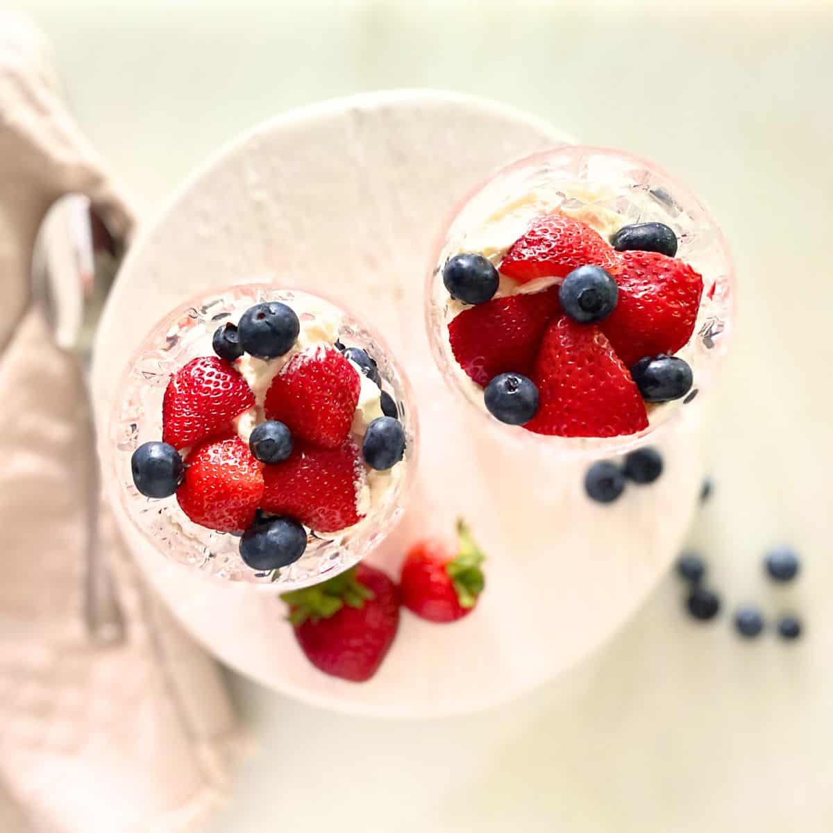 berries and cream in double old-fashioned glasses