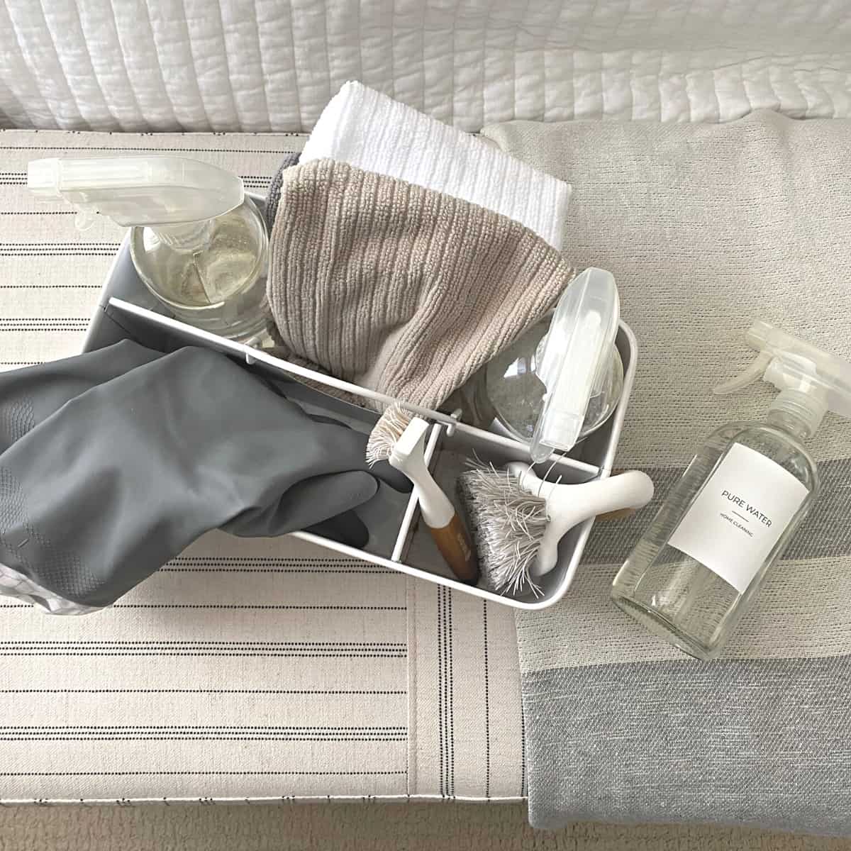 White bathroom caddy with cleaning products, gloves and towels