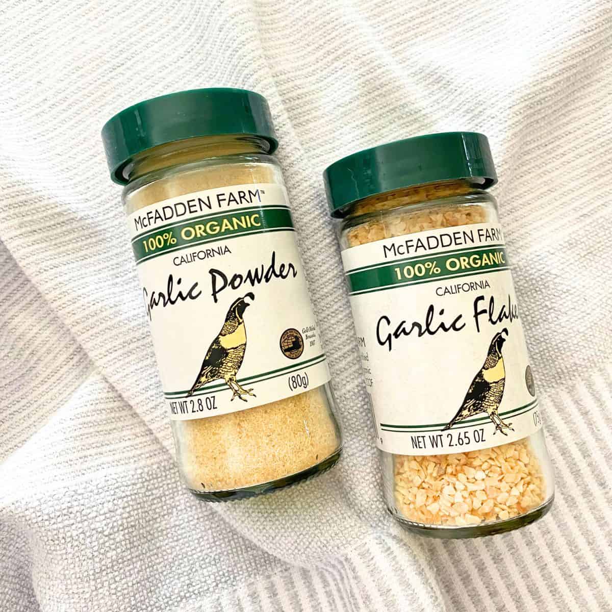 Glass jars of McFadden Farm one-hundred percent garlic powder and garlic flakes