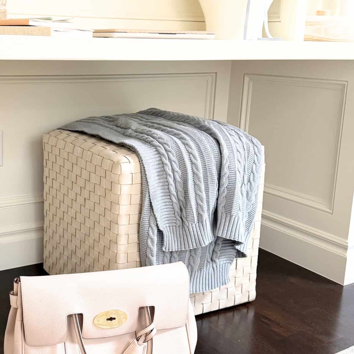 leather ottoman with blue blanket draped over