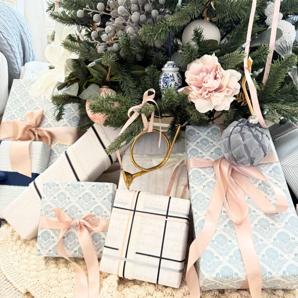 presents wrapped in blue and pink paper under a tree