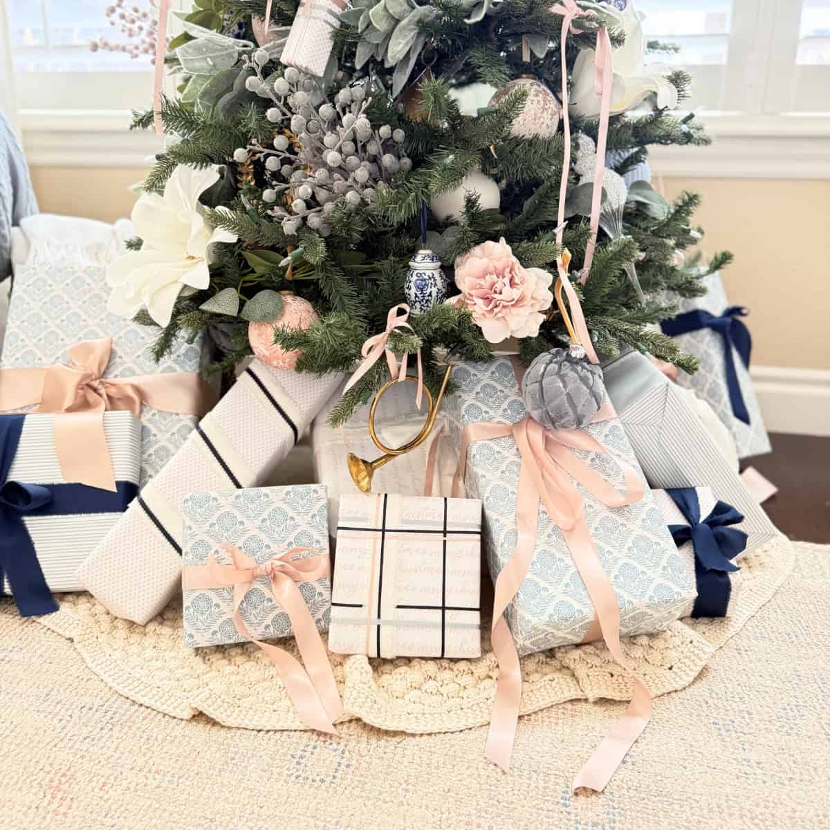 presents wrapped in blue and pink paper under a tree