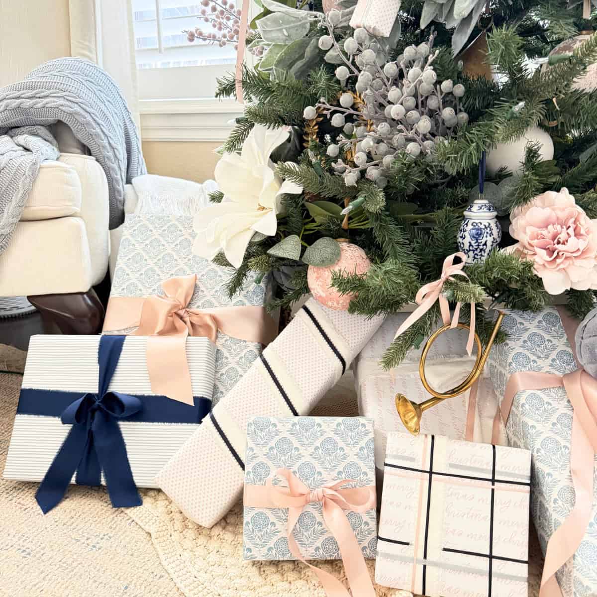 blue pink and white wrapped gifts under a tree