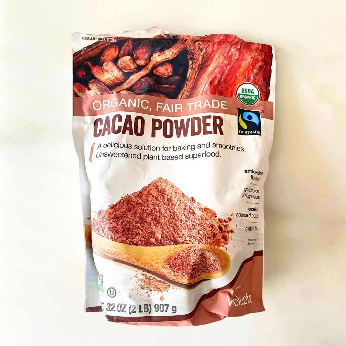 Raw, unsweetened cacao powder laying on a white marble countertop