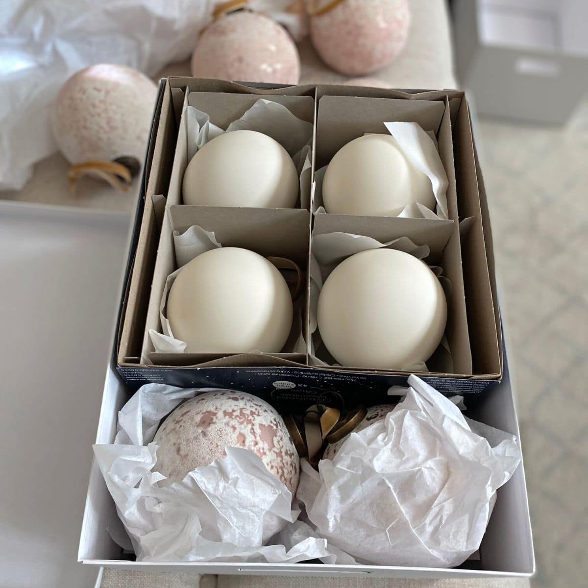 white and pink glass ball ornaments in a box