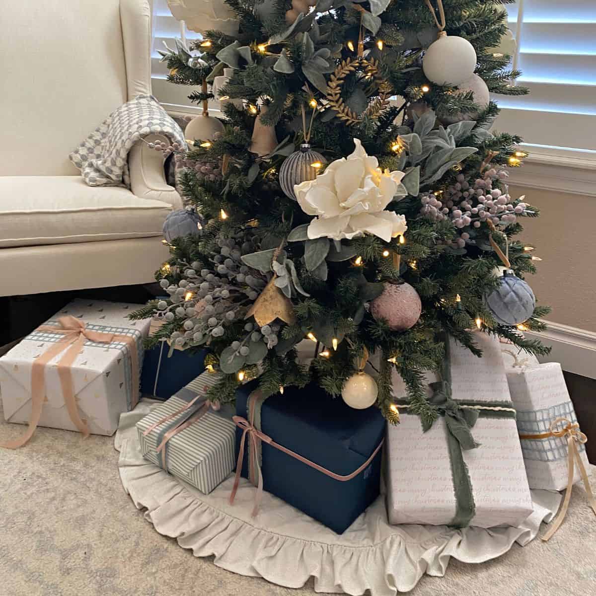 Pastel gift wrapped Christmas presents under a tree