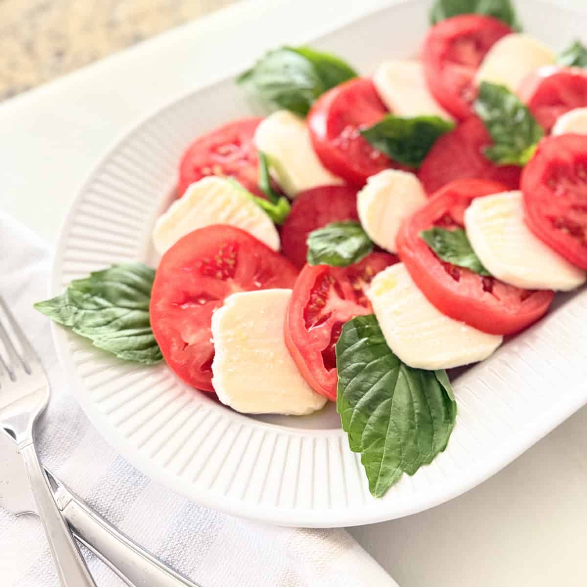 Caprese salad served on a white platter