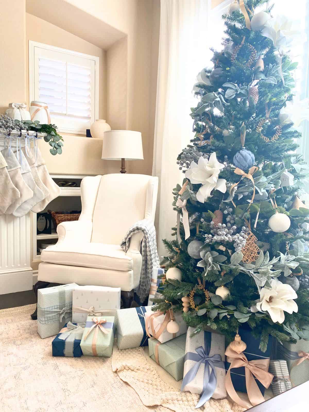 christmas tree with blue, white and green gift wrapped presents under it