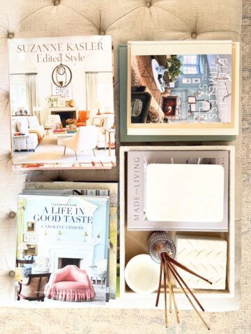 overhead stacks of coffee table books on linen tufted ottoman