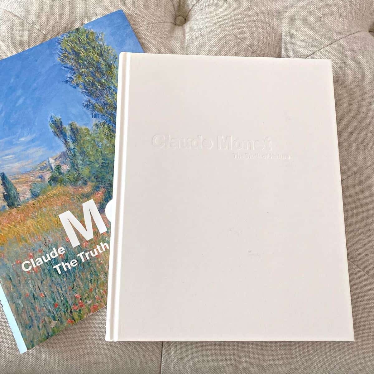 White coffee table book of Claude Monet's work sits atop the removed colorful dust cover.