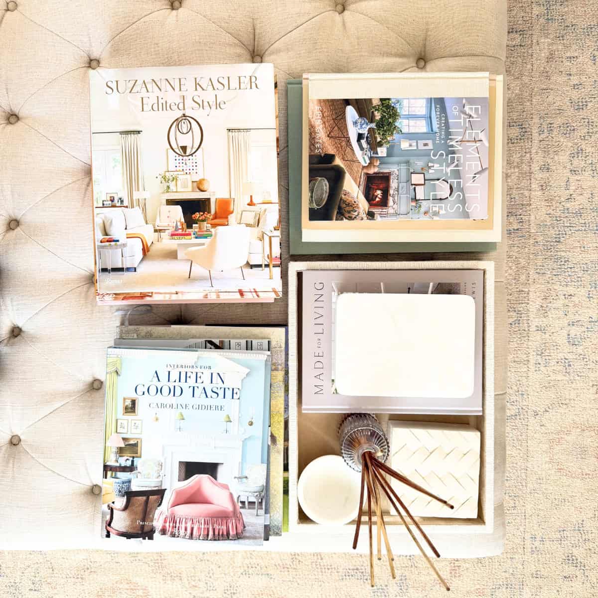 overhead stacks of coffee table books on linen tufted ottoman