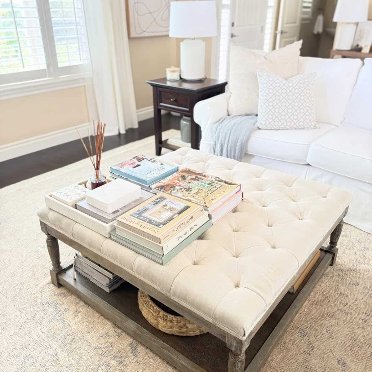 books and tray styled on a tufted ottoman