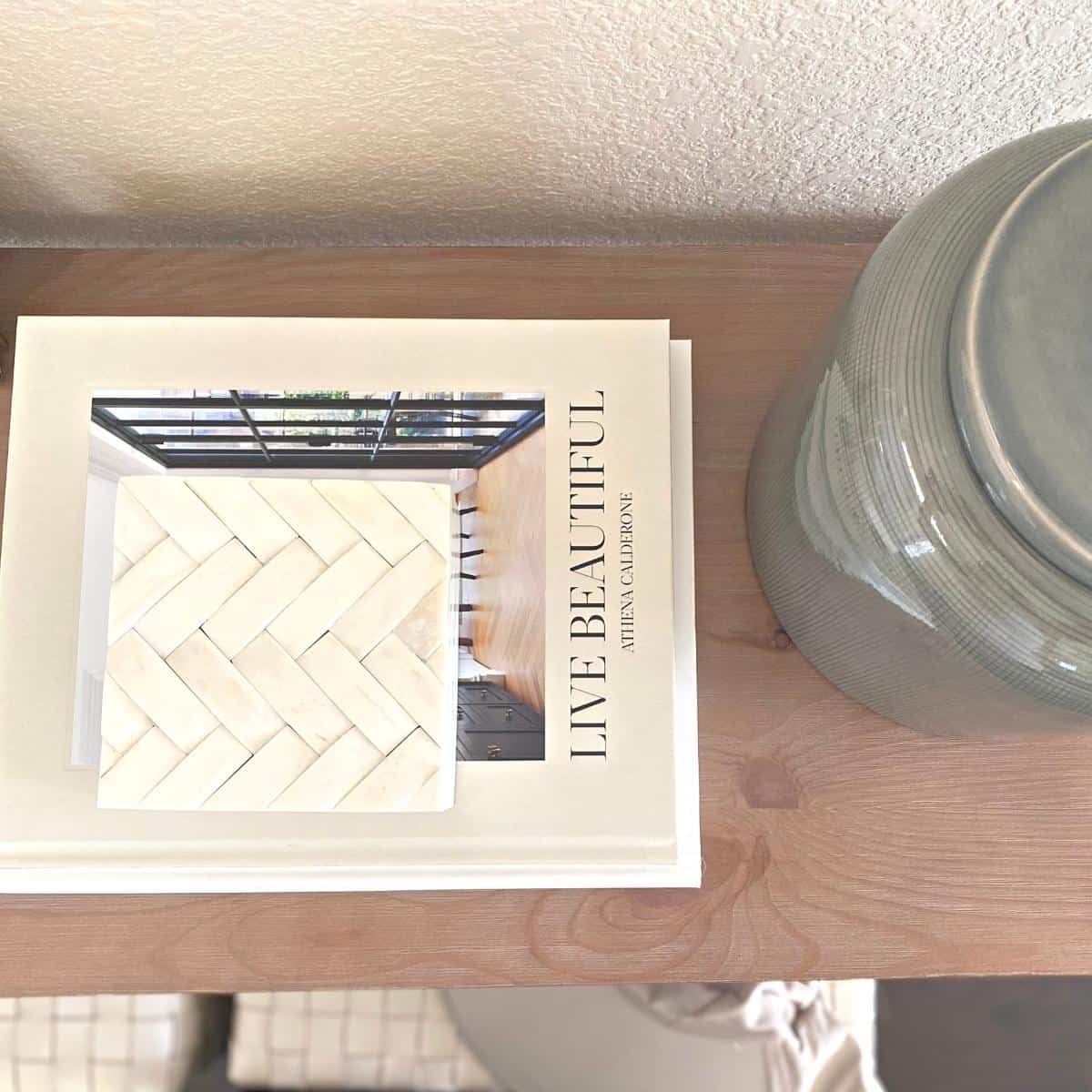 Coffee table books and a white vase style a console table from above