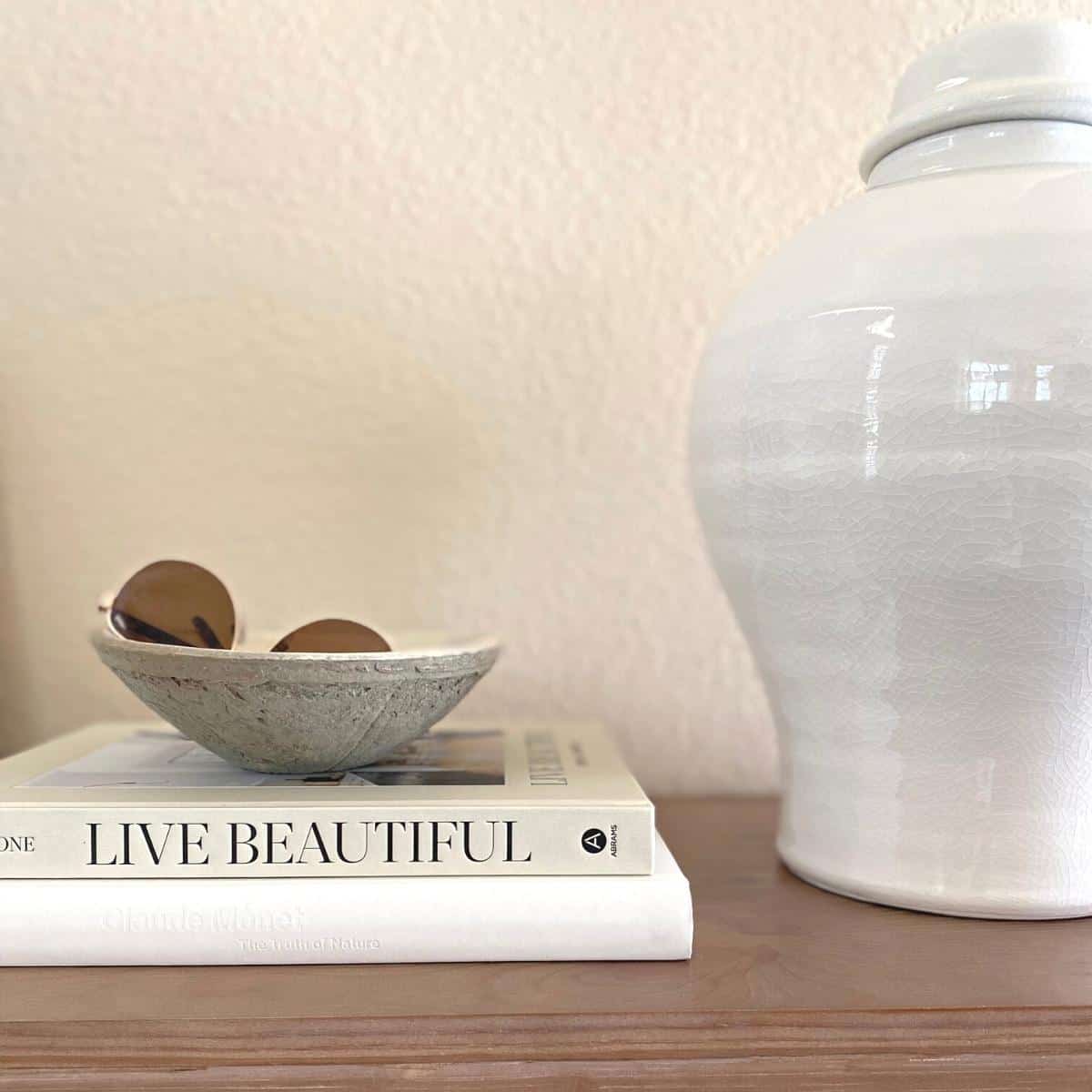 Coffee table books and a white vase style a console table