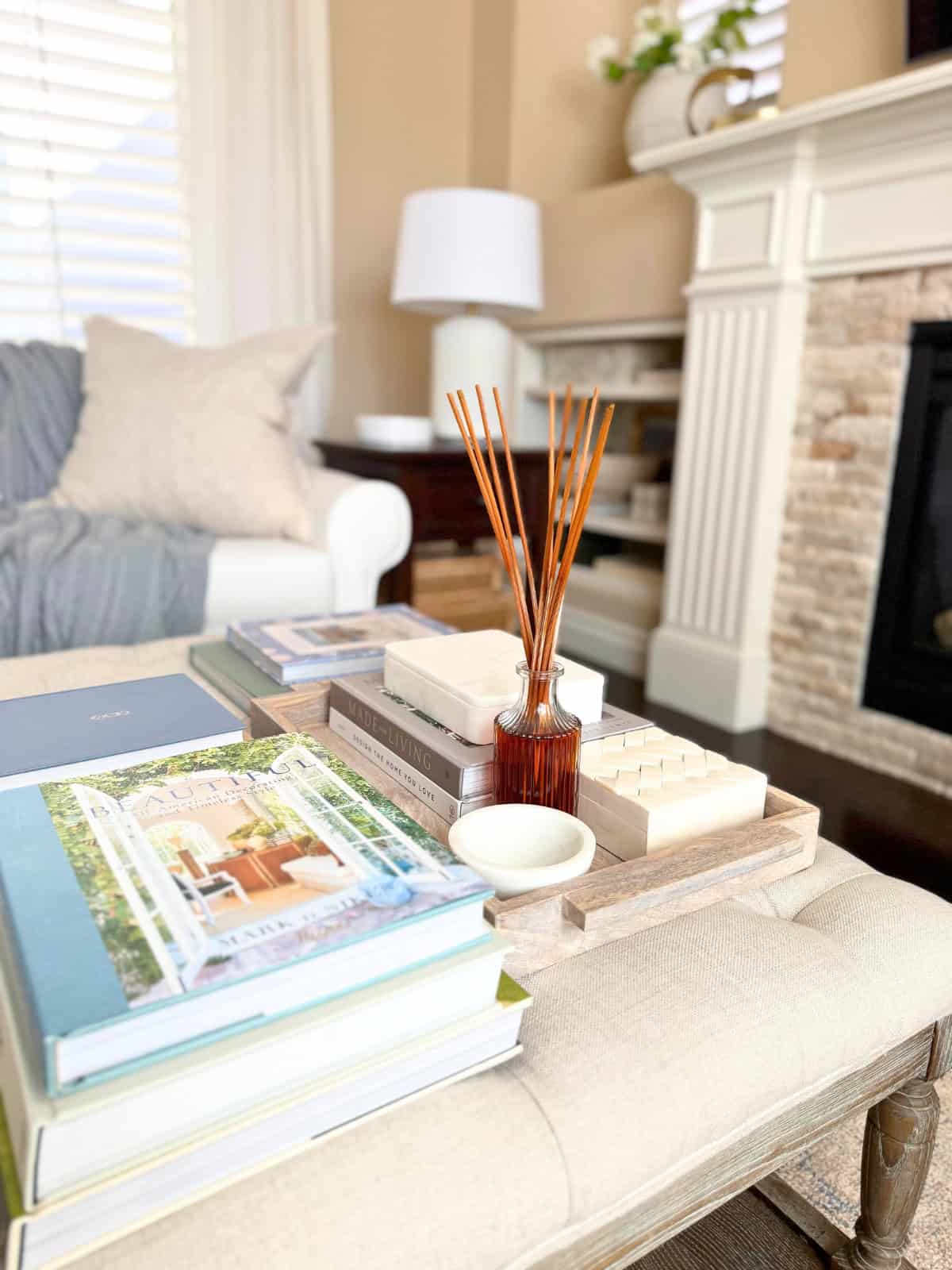 tufted ottoman styled with books in a living room