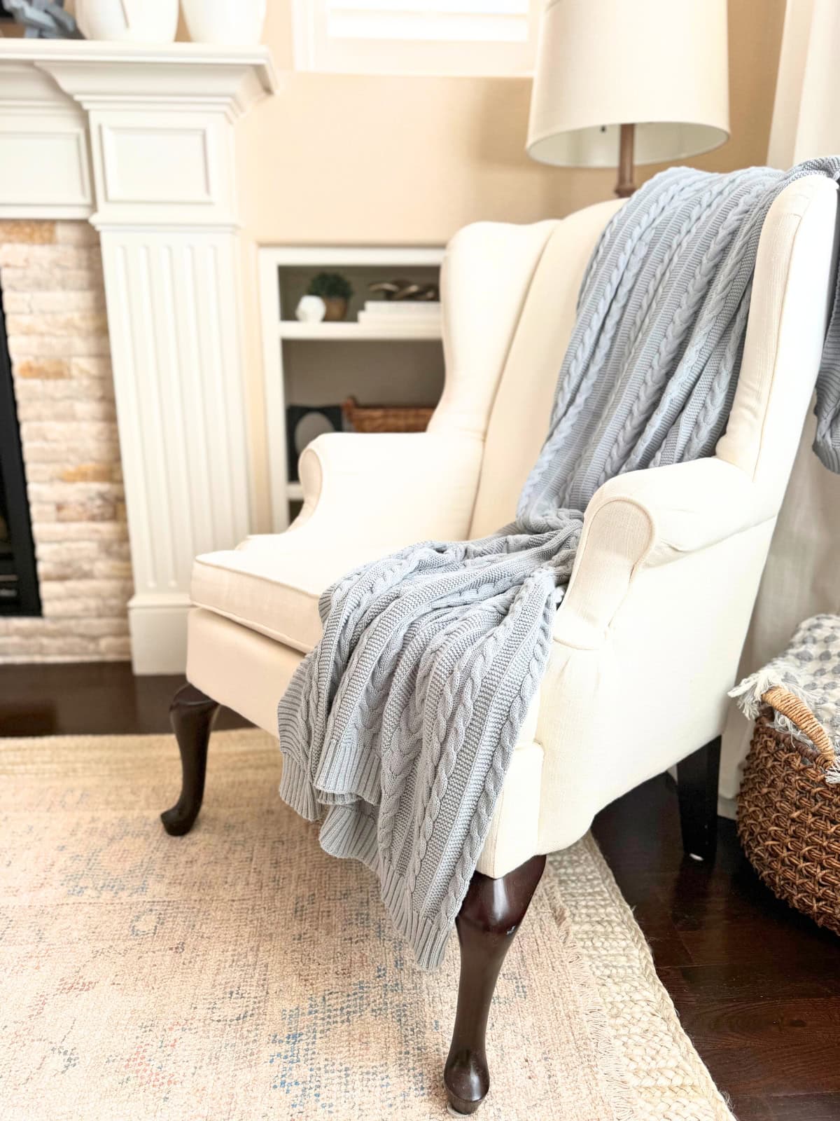 cozy ivory basketweave wingback chair with draped blue throw blanket