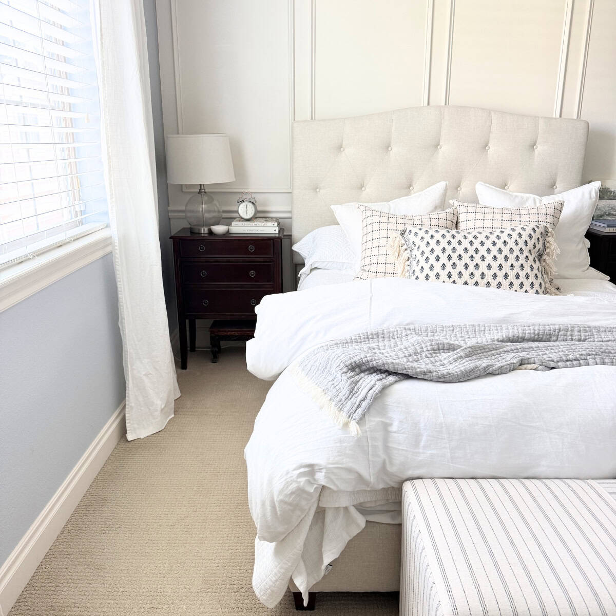 upholstered bed next to dark wood nightstand