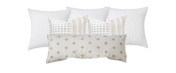 Set of throw pillows for a king size bed. Three all white euro pillows in the back, two twenty-four inch block print patterned pillows in the middle and an oversized lumbar pillow in a gray dot print in the front.