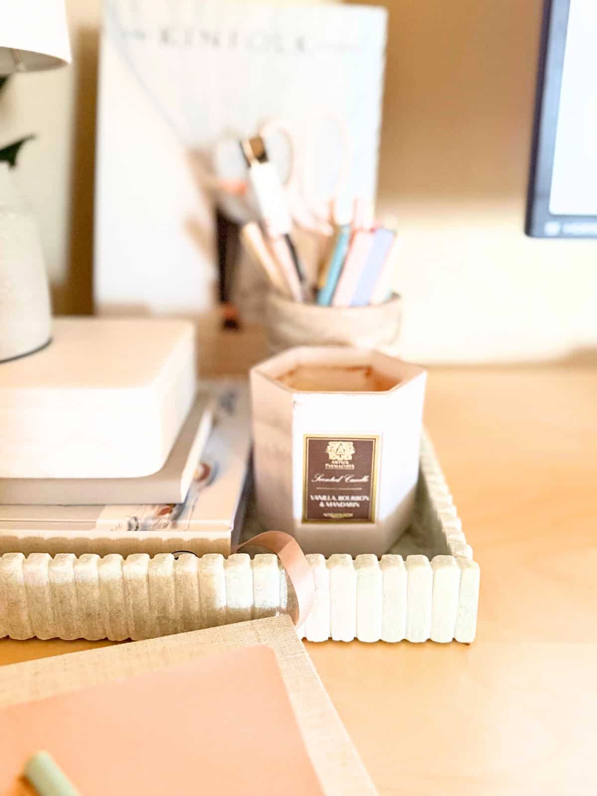 vanilla candle in marble fluted tray on a desk