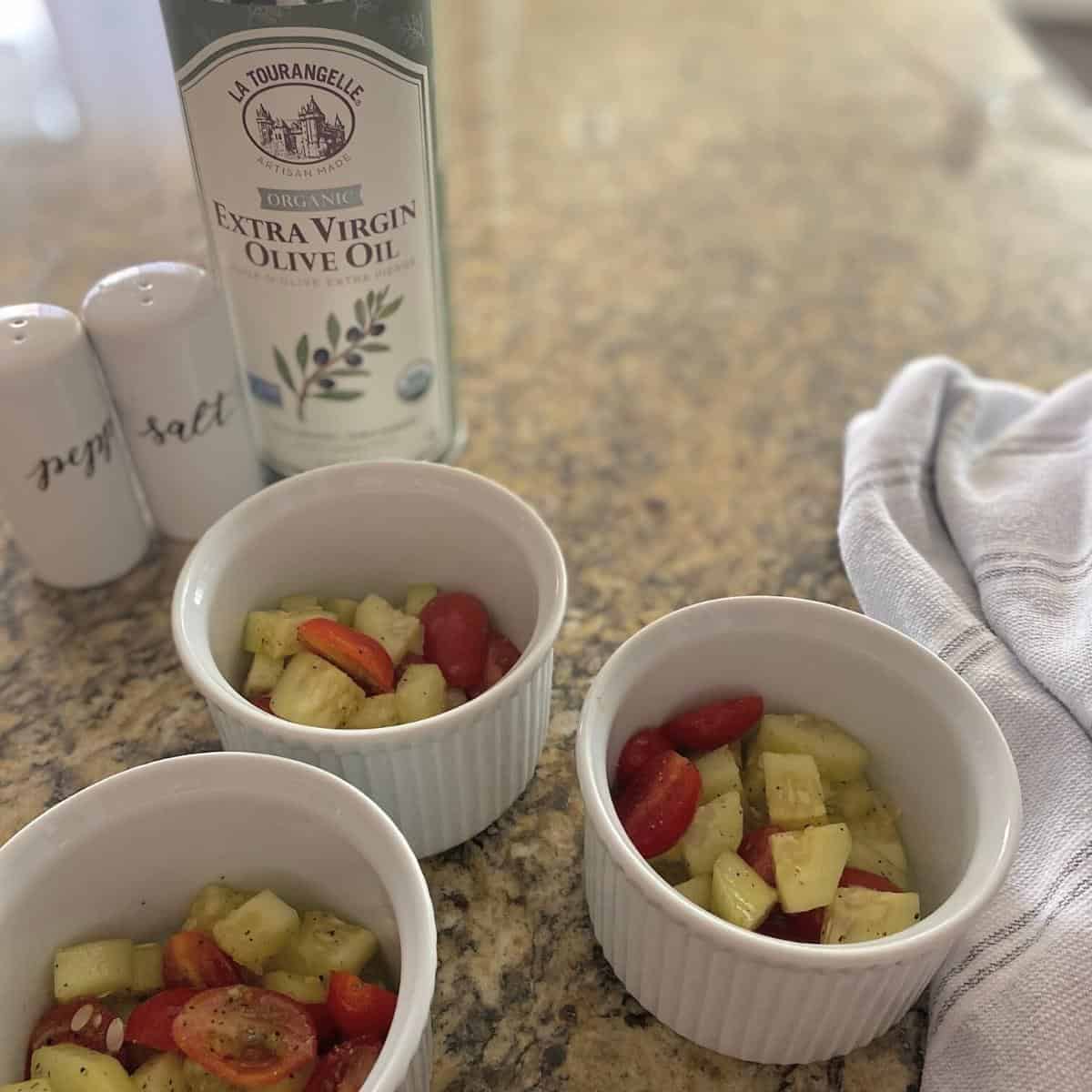 Cucumber and tomato salad served in three white ramekins