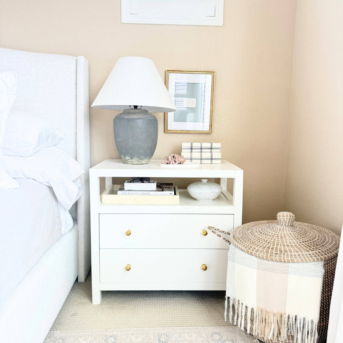 decorated nightstand next to basket with blanket