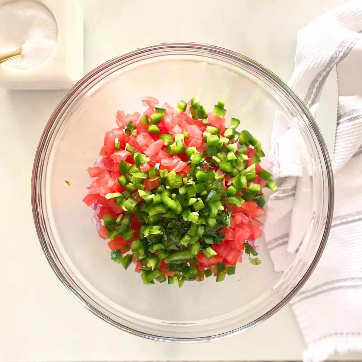 finely diced, tomatoes, red onion and jalapeno in glass mixing bowl