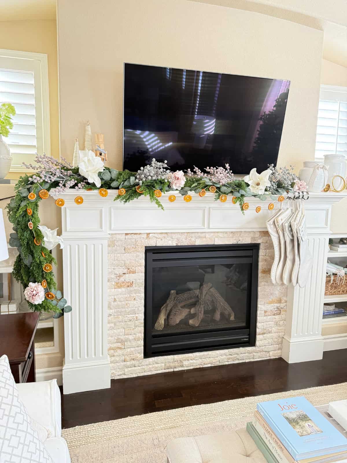 fireplace mantel decorated for christmas with orange garland