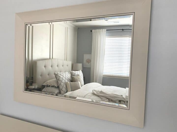 The first photo of after the DIY frame makeover, showing the mirror hung on a wall.