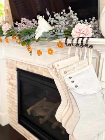 fireplace mantel decorated for christmas with orange garland