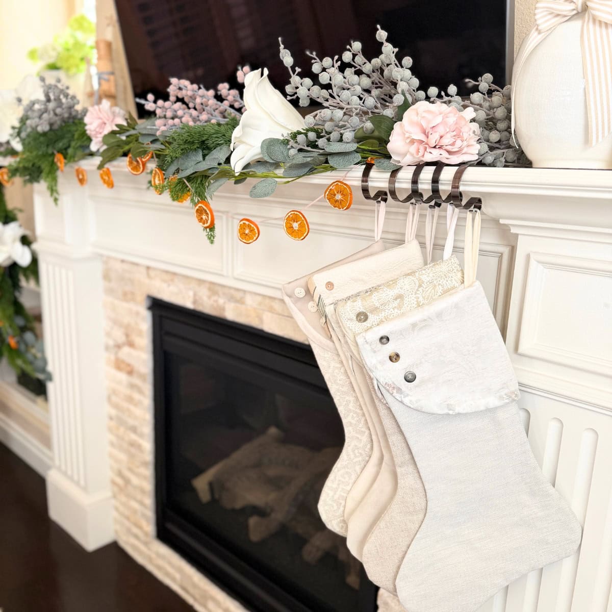 fireplace mantel decorated for christmas with orange garland