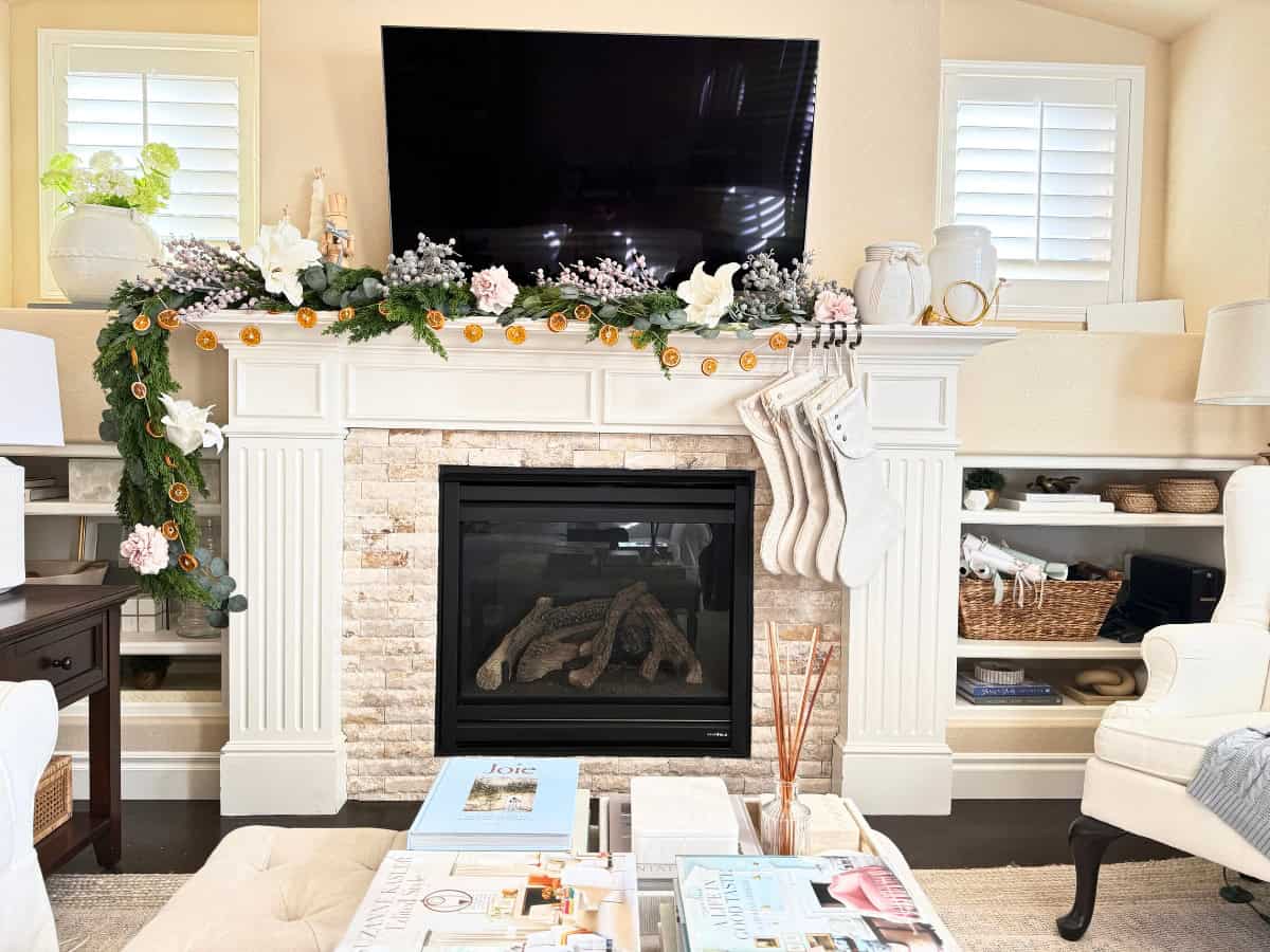 fireplace mantel decorated with orange garland for christmas