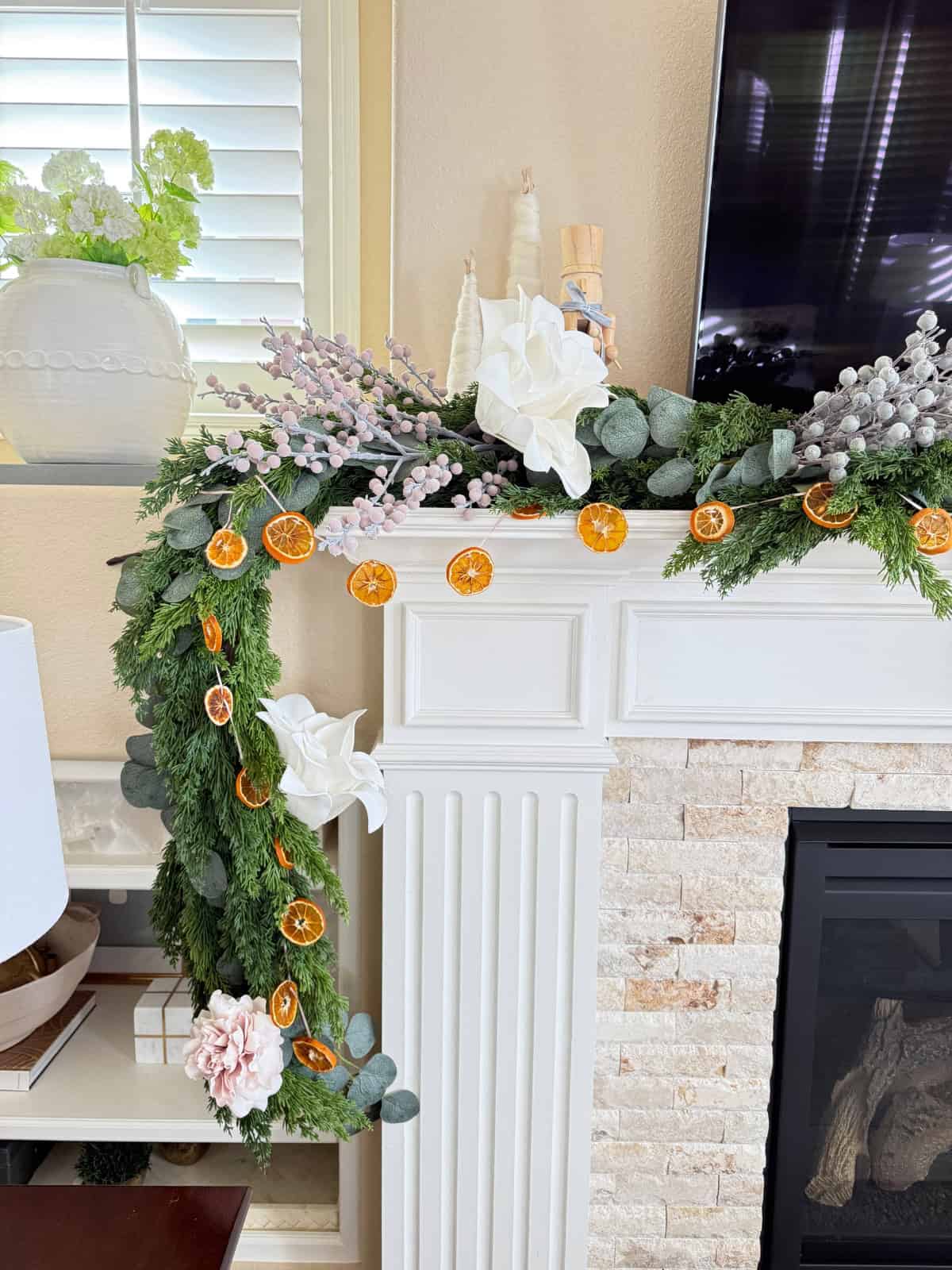 fireplace mantel decorated for christmas with orange garland