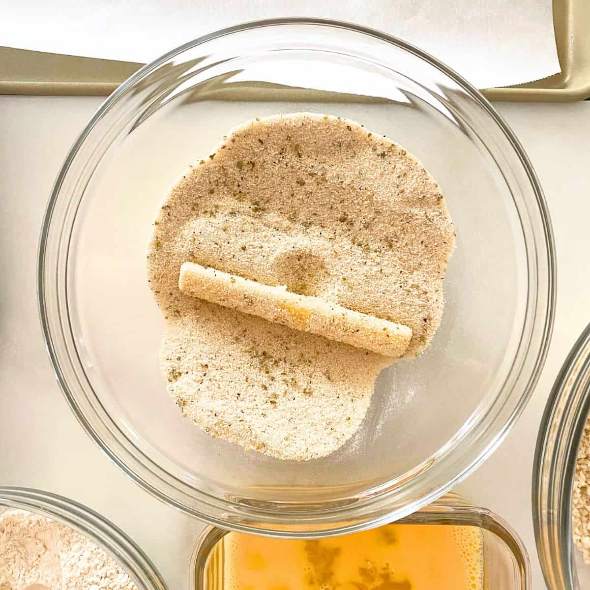 step three is dredge cheese stick in fine bread crumb mixture