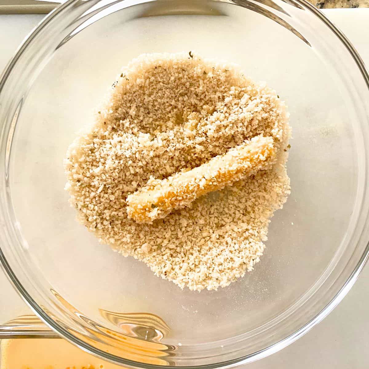 fifth and final step is dredge cheese stick in panko bread crumbs