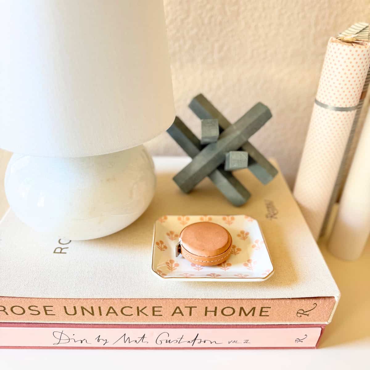 marble lamp and other decor stacked on two books atop a dresser