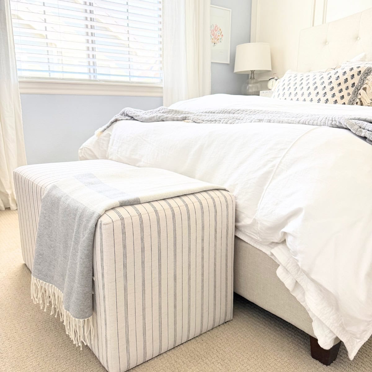 striped bench at the end of a bed