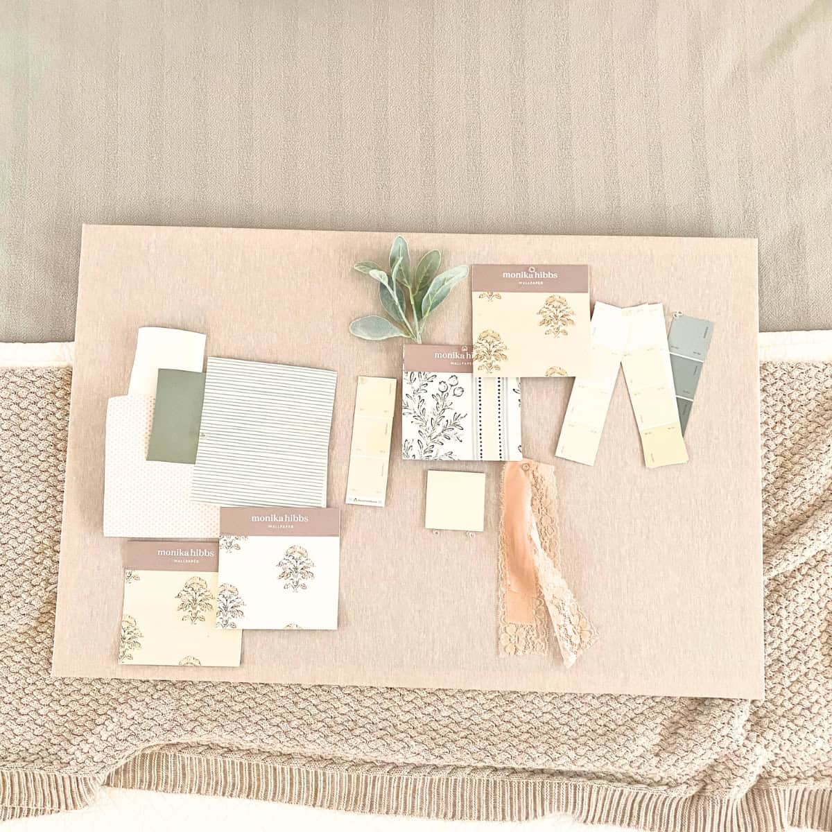 diy linen fabric pinboard with wallpaper and paint samples pinned to it