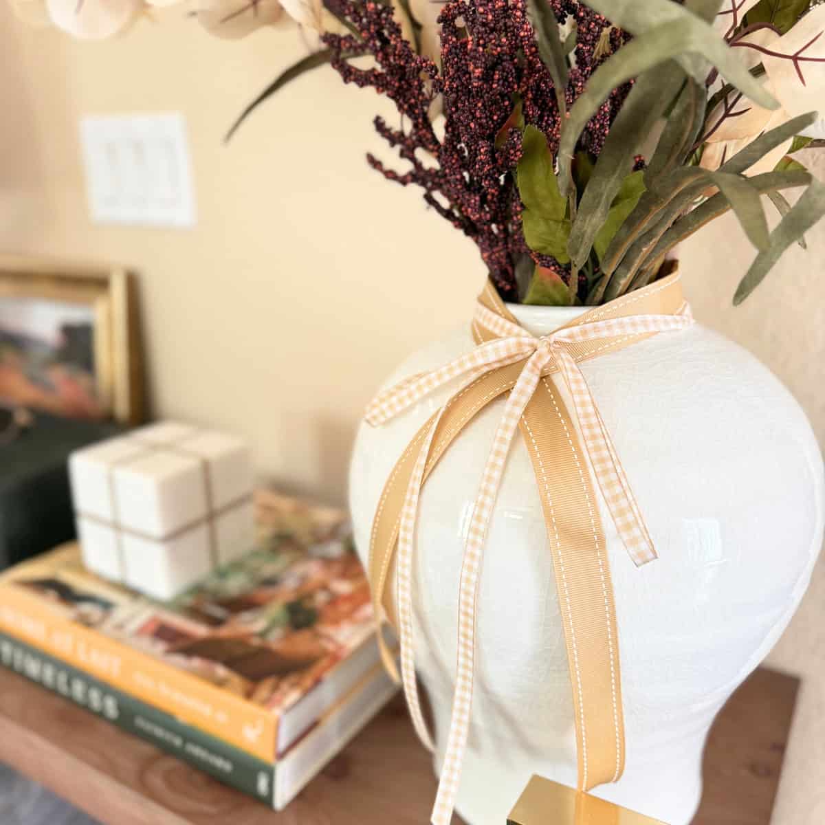 warm caramel ribbon around a white vase with faux stems