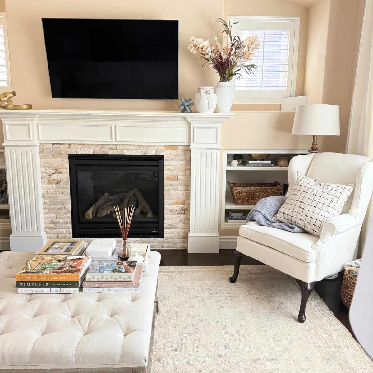 fireplace mantel styled with a white vase with faux stems in fall colors