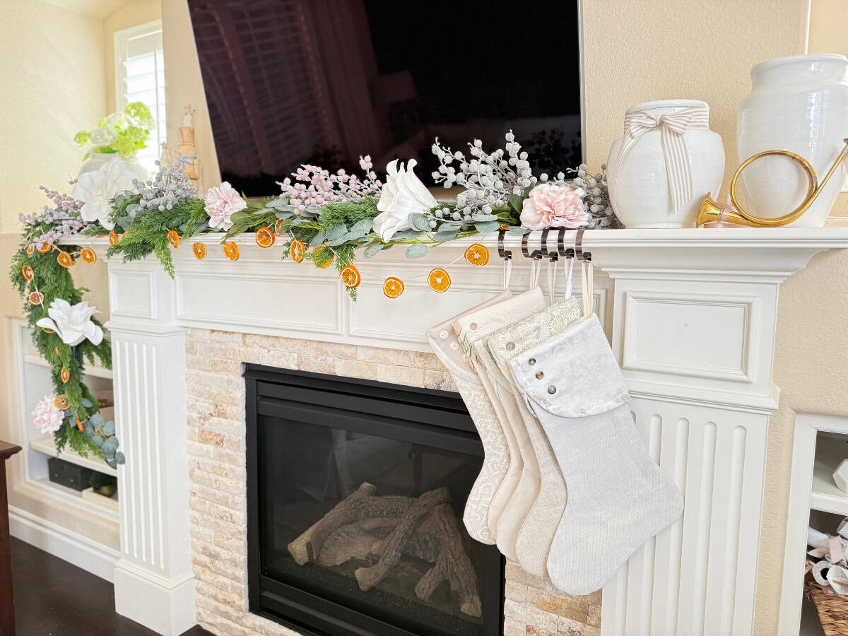 fireplace mantel styled in orange and cedar garland for christmas