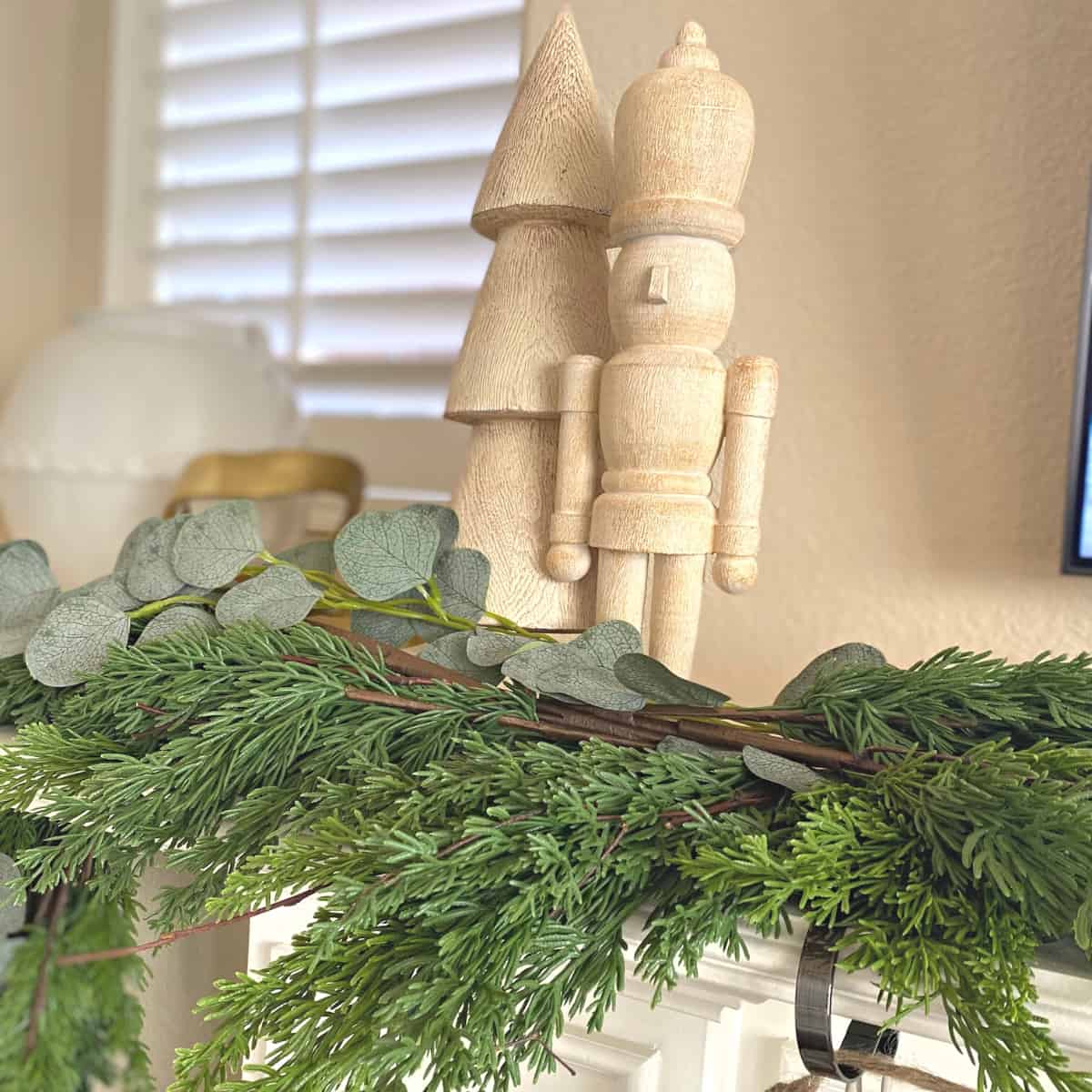 Wooden holiday tree and nutcracker with garland beneath