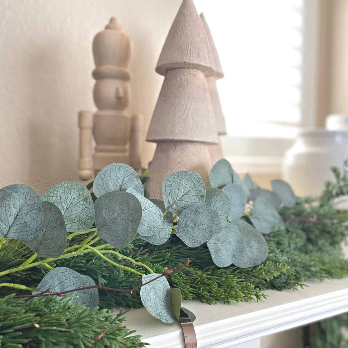 Wooden holiday tree and nutcracker with garland beneath