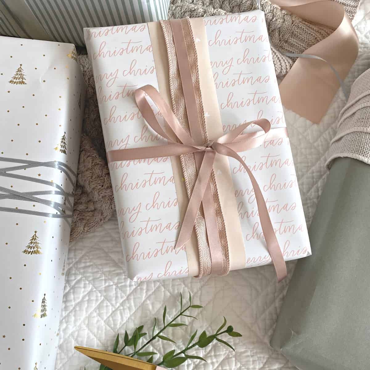 White and pink "merry Christmas" wrapped gift, layered with pink satin and glittery pink wired ribbon bows