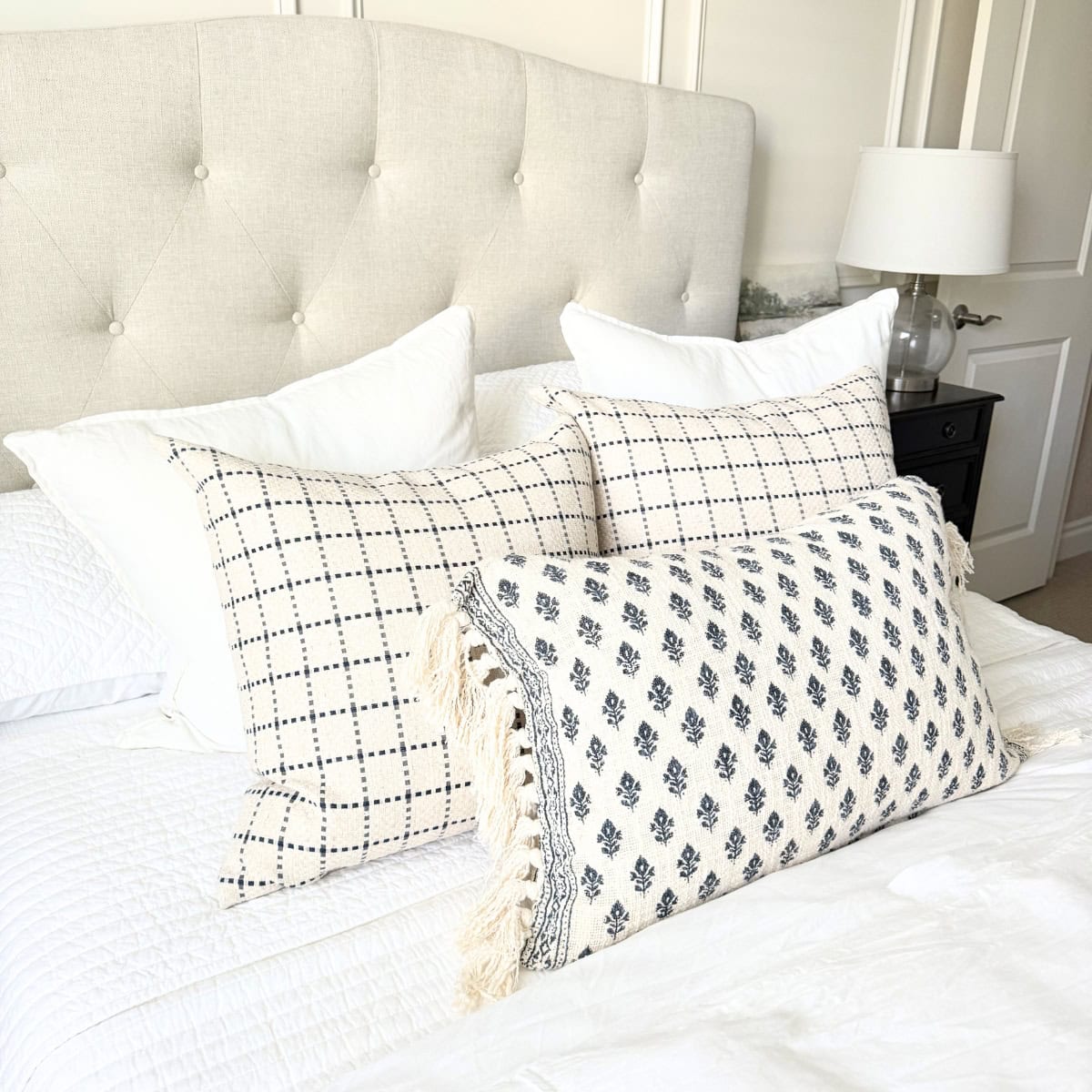 throw pillows in plaid and block print on bed